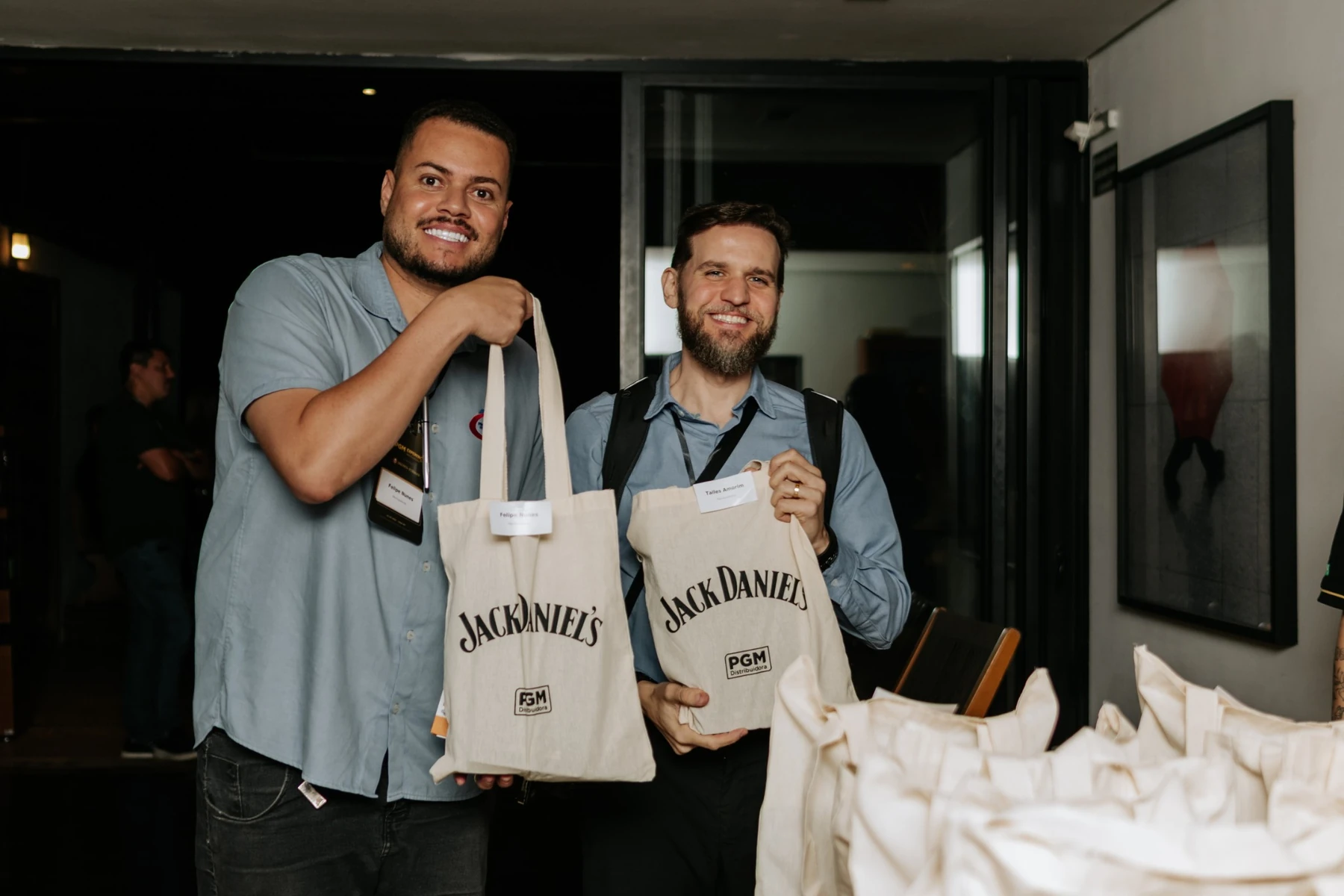 Dois participantes com sacolas Jack Daniel’s e PGM.